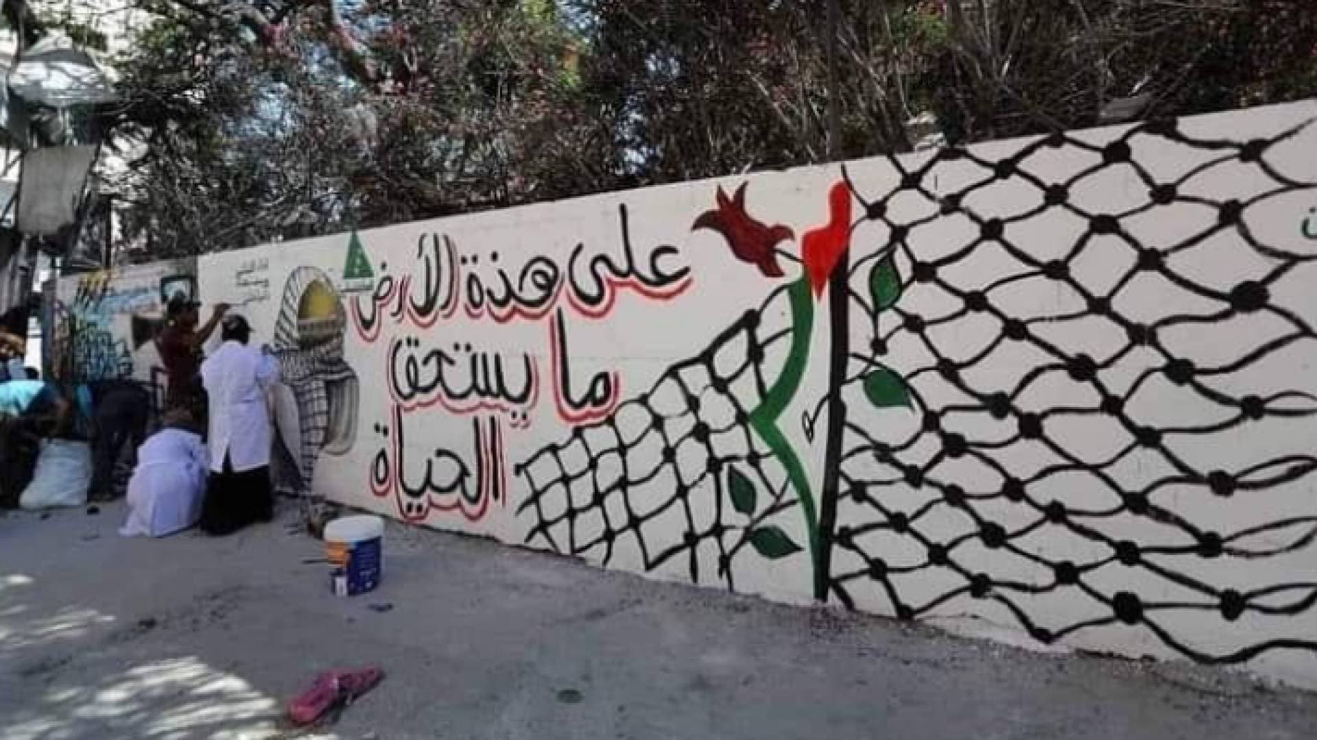 رسم جدارية بجانب برج الجوهرة الذي دمر خلال العدوان الأخير على غزة - صور